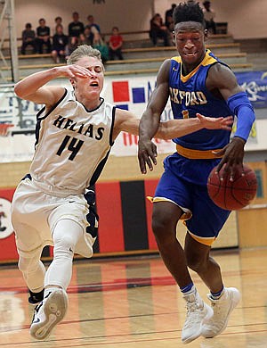 Landon Harrison of Helias attempts to steal the ball from Jarkel Joiner of Oxford, Miss., during Wednesday night's game at Fleming Fieldhouse.