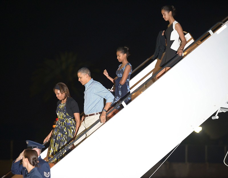 President Barack Obama, first lady Michelle Obama, and daughters Sasha and Malia, arrive at Joint Base Pearl Harbor-Hickam for a family vacation on Saturday, Dec. 21, 2013 in Honolulu, Hawaii. 