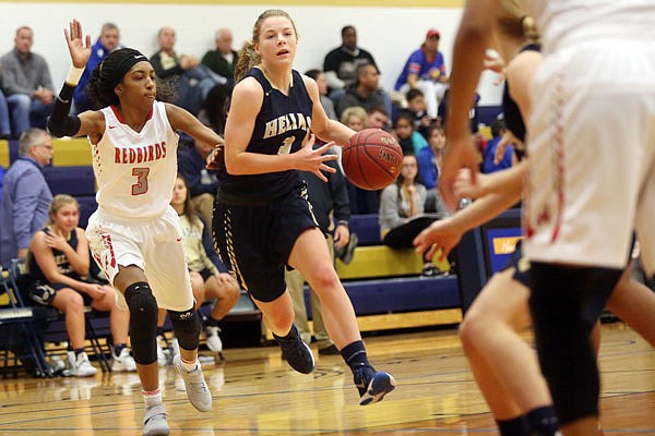 Morgan Wieberg of Helias heads toward the basket as Alexia Rodgers of Alton defends during Thursday's game in the State Farm Holiday Hoops Invitational at Rackers Fieldhouse.