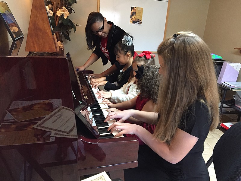 Donaylé Cardenas works with piano students at the Twice as Nice Music Academy.