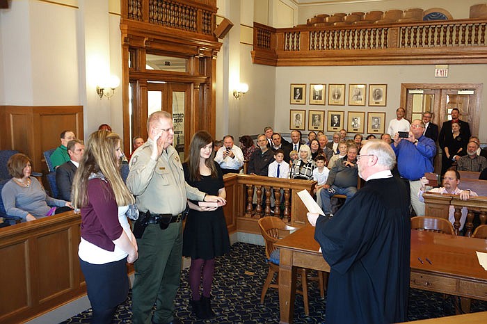 With his daughters at his side, John Wheeler takes the oath of office as Cole County Sheriff during a brief swearing-in ceremony in the Division I Courtroom Friday morning. He and other county officials were sworn in byCole County Circuit Judge Jon Beetem, at right. 