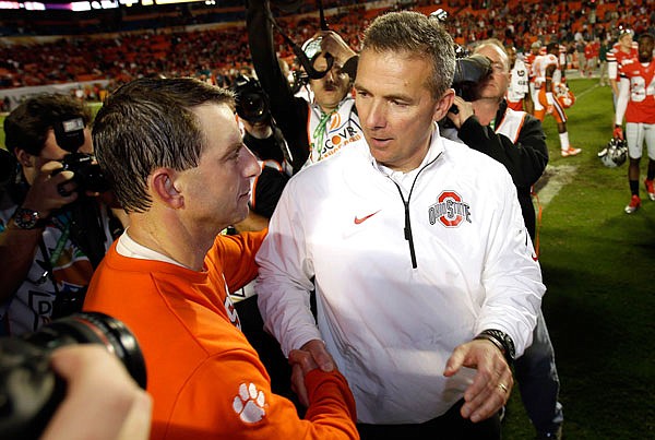 In this Jan. 4, 2014, file photo, Ohio State coach Urban Meyer (right) shakes hands with Clemson coach Dabo Swinney after the Orange Bowl in Miami Gardens, Fla. Clemson defeated Ohio State 40-35.