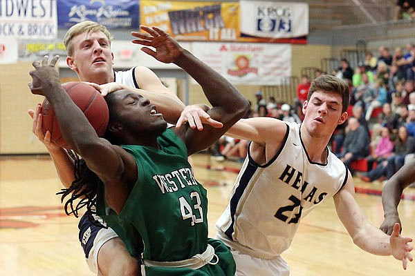 Helias' Nathan Bax (back) and Dalton Weaver (right) fight Anthony Lewis of Western (Ky.) for the ball during Friday night's third-place game of the Great 8 Classic at Fleming Fieldhouse. Helias won 50-33.