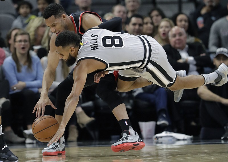 San Antonio Spurs guard Patty Mills (8) and Portland Trail Blazers guard Evan Turner chase a loose ball during the first half of an NBA basketball game, Friday, Dec. 30, 2016, in San Antonio.