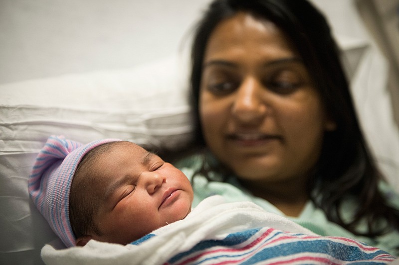 Newborn Jina Patel sleeps in the arms of her mother, Amisha Patel, early Sunday at CHRISTUS St. Michael. She is the first baby born in Texarkana this year. Amisha and her husband, Sameer, live in Hope, Ark. Jina is their second child.