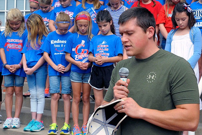 The Rev. Casey Malley, youth pastor at First Baptist Church-California, leads a prayer following the flag-raising ceremony to kick-off the Ozark Ham and Turkey Festival in September. He has accepted a second term as president of the California Ministerial Alliance.