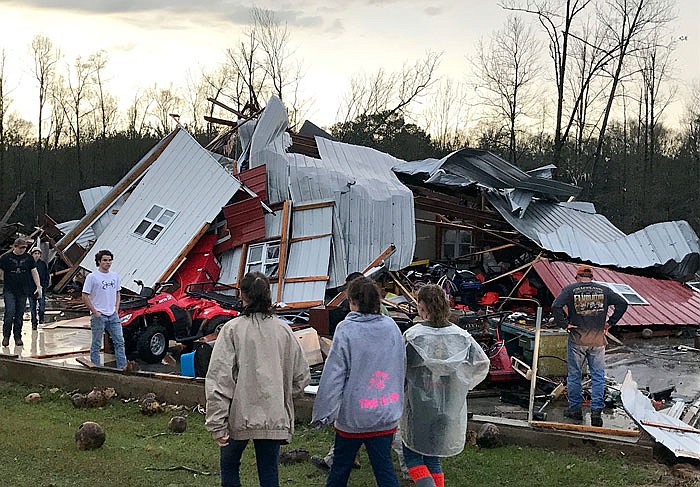 People examine a barn owned by the Miller family that was destroyed during a storm south of Mount Olive, Mississippi, on Monday.
