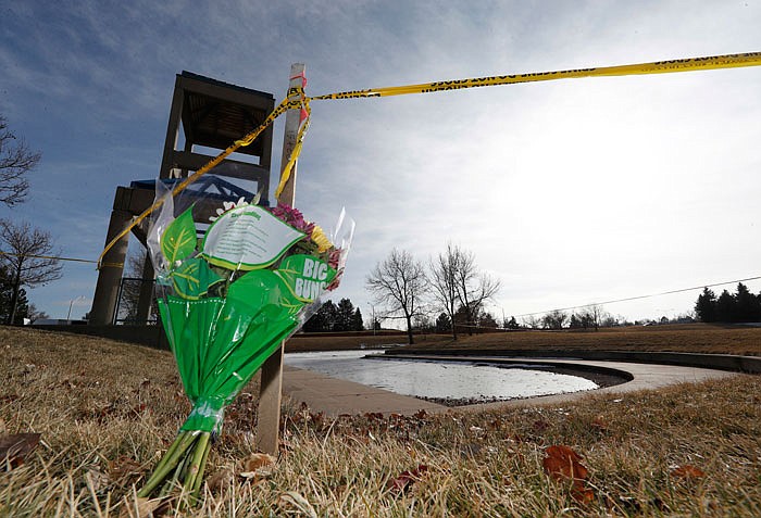 A bouquet of flowers stands below a rope of crime tape around a small, ice-covered lake Tuesday in Aurora, Colorado. Divers looking for a 6-year-old boy who apparently wandered away from his family's home on New Year's Eve found the body of a child in the lake just before noon Tuesday.
