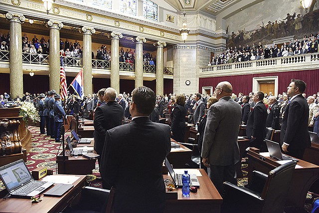 Members of the Missouri House of Representatives stand Wednesday for the Pledge of Allegience during ceremonies as the 99th General Assembly gets underway. The Missouri Highway Patrol provided the day's color guard for House opening day activities.