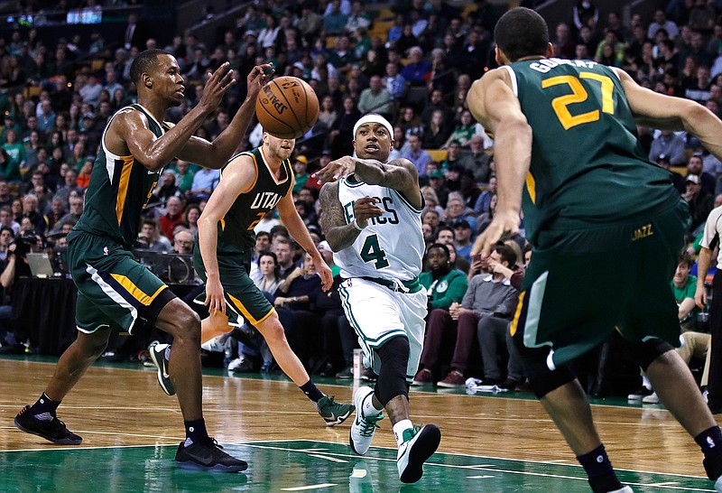 Boston Celtics guard Isaiah Thomas (4) passes the ball as he drives between the Utah Jazz during the second half of an NBA basketball game in Boston, Tuesday, Jan. 3, 2017. Thomas had 29 points and 15 assists as the Celtics defeated the Jazz 115-104. 