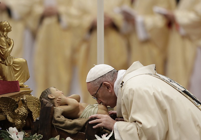 Pope Francis kisses a statue of the Divine Infant as he celebrates an Epiphany Mass in St. Peter's Basilica at the Vatican, Friday, Jan. 6, 2017. 