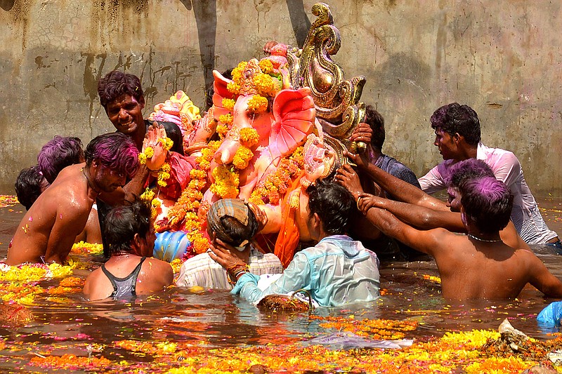 Indian devotees immersing the Hindu god Ganesha during Ganesh Chaturthi, a popular 11-day religious festival annually celebrated across India.