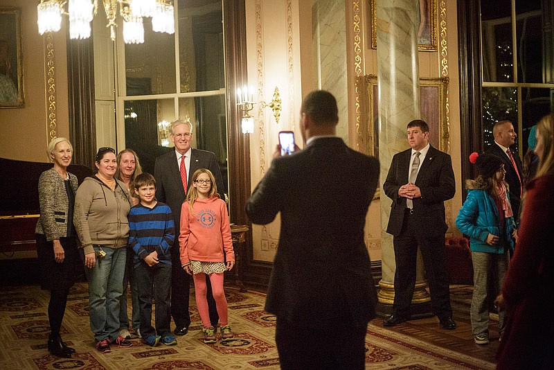 Missouri Gov. Jay Nixon and his wife Georganne pose with mansion tourists during the 2015 Governor's Mansion holiday tours.