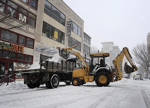 Road crews clear the street during a snowstorm on Saturday, Jan. 7, 2016 in Norfolk, Va. Snow pounded a swath of Virginia on Saturday as hundreds crashed on icy roads, thousands lost power and blizzard warnings were issued along the East Coast. 