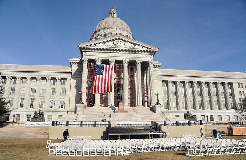 While crews from the Office of Administration haul in and set up rows of chairs for Monday's ceremony, employees of Verslues Construction unfurl a large American flag in the south portico. In addition, a Missouri flag will hang on the right side to serve as the backdrop for Gov.-elect Eric Greitens' inauguration Monday.