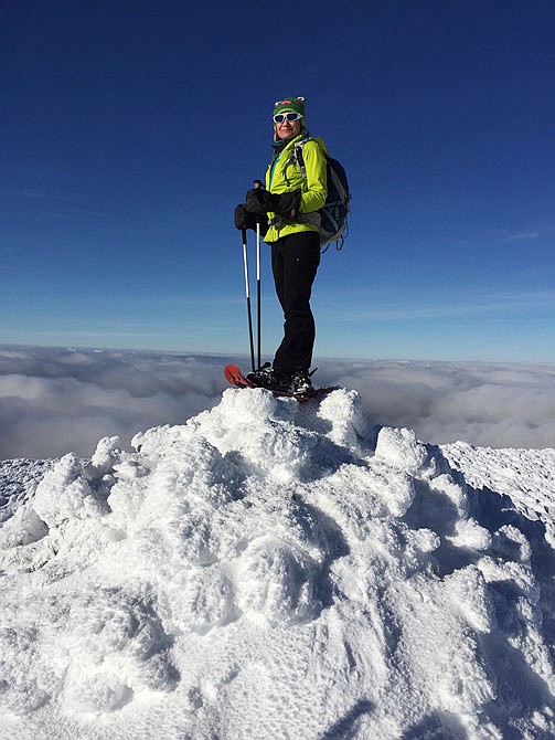 Sue Johnston poses last month on top of Mount Eisenhower in the White Mountains of New Hampshire. Johnston is believed to be the first person to complete an ambitious hiking challenge in the White Mountains in a single year. 