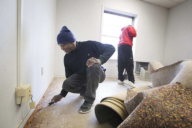 Donald Linear, above left, and another client of Randy Sams' Outreach center pull up the carpet and do other work Monday at the shelter's new administration office. Randy Sams recently bought the former Hospice of Texarkana facility at the corner of Martin Luther King Jr. Boulevard and Spruce Street, below, in Texarkana, Texas. They plan to house the center's administrative offices, commercial bakery, and have a client computer lab/training center in the 8,500 square foot space.