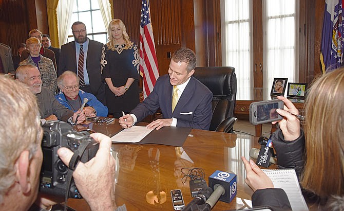 Surrounded by media in his first official act as Missouri's 56th governor, Eric Greitens signed executive orders after his inauguration in January in his Capitol office.
