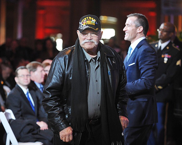 Vietnam veteran Bob Sneller, walks away after greeting Gov.-elect Eric Greitens, background right in light, as he hosted an event in the Capitol Rotunda to honor Missouri heroes prior to being sworn in as the governor.