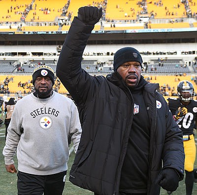 Steelers linebackers coach Joey Porter (right) and head coach Mike Tomlin leave the field after Sunday's win against the Dolphins in Pittsburgh.