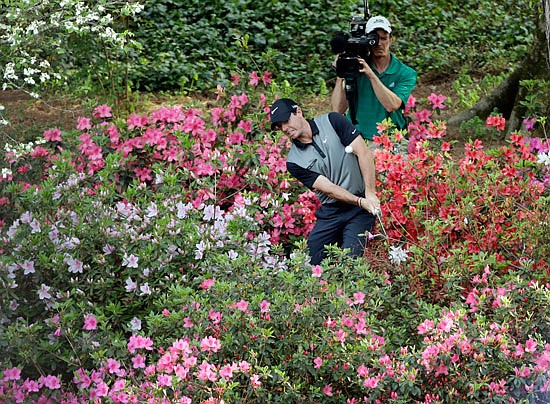 In this April 11, 2014, file photo, Rory McIlroy hits out of the azaleas to the 13th green during the second round of the Masters in Augusta, Ga.