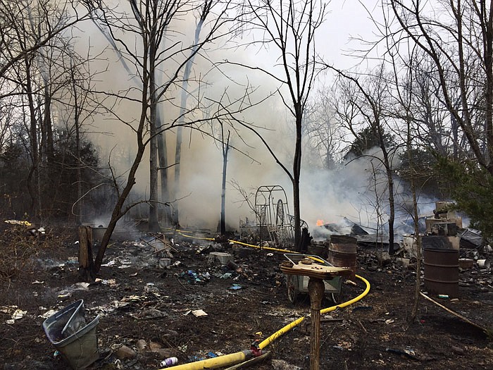 Cole County Fire Protection District firefighters fight a fire that consumed a building and adjacent wooded acreage on Thursday morning, Jan. 12, 2017 along Market Road at Eugene.