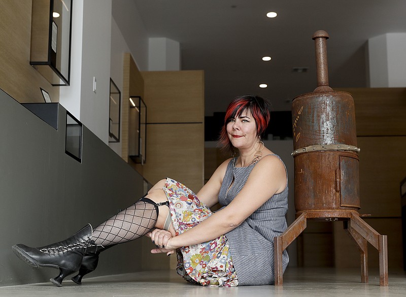 Amber Clisura poses for a picture next to the meat smoker she donated at the new Museum of Broken Relationships Wednesday, Dec. 28, 2016, in Los Angeles. The four-legged smoker had been a treasured handmade gift, but eventually Clisura couldn't bear to look at it. The Museum of Broken Relationships displays artifacts from failed unions, most of them mundane under ordinary circumstances. 