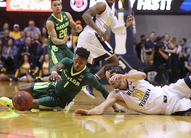 Baylor guard Wendell Mitchell (1) and West Virginia forward Nathan Adrian (11) dive for a loose ball during the first half of an NCAA college basketball game, Tuesday, Jan. 10, 2017, in Morgantown, W.Va. 