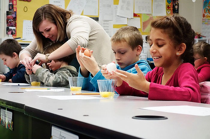 Bush Elementary School guidance counselor Chelsea Baker helps a student crack an egg into a cup on Thursday.