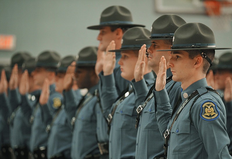 Members of the 103rd Recruit Class of the Missouri Highway Patrol repeat their oath as they are sworn in and promoted to trooper during a December 2016 commencement ceremony at the patrol's gymnasium in Jefferson City.