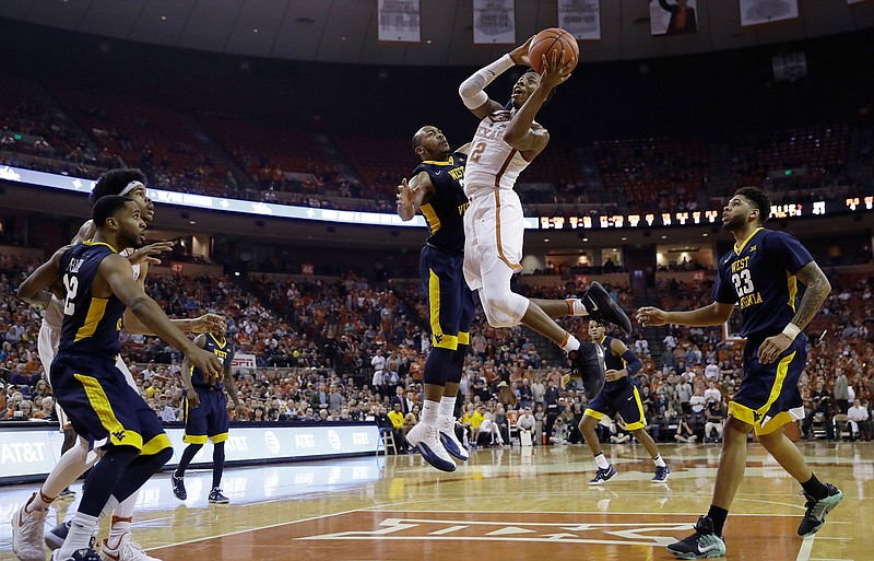 Texas guard Kerwin Roach Jr. (12) drives to the basket against West Virginia guard Jevon Carter (2) during the second half of an NCAA college basketball game, Saturday, Jan. 14, 2017, in Austin, Texas. West Virginia won 74-72. 