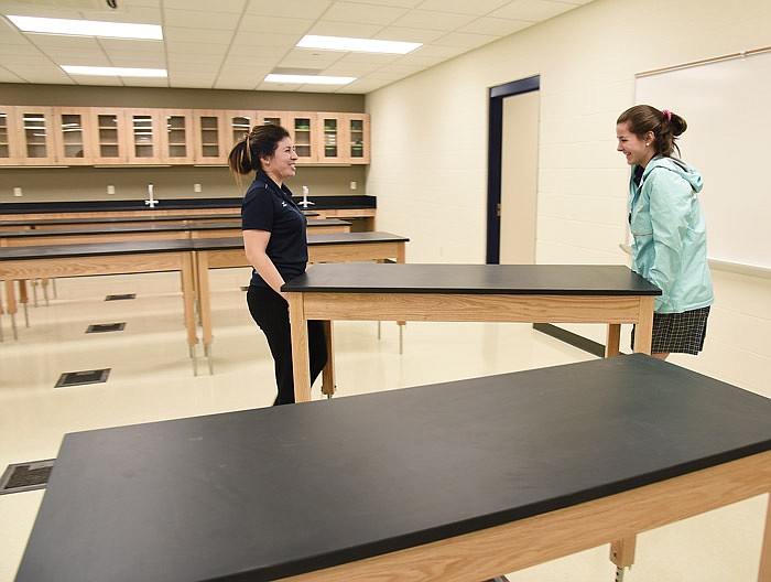 FILE: Krizzia Chisolm, left, and sophomore Reagan Bernskoetter carry in a table to one of the science rooms at Helias Catholic High School. Staff, teachers and students got a head start Thursday, Jan. 12, 2017, on moving into the newly completed section of the school.