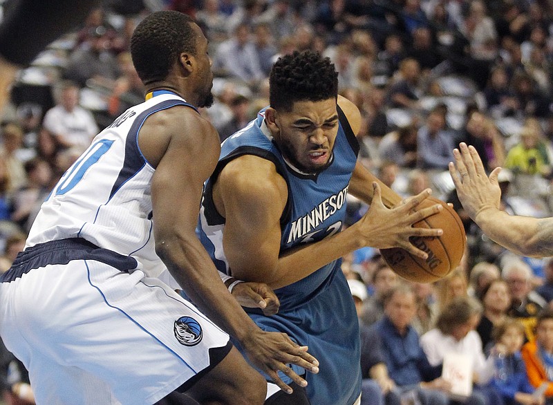 Minnesota Timberwolves center Karl-Anthony Towns, right, drives against Dallas Mavericks forward Harrison Barnes during the first half of an NBA basketball game, Sunday, Jan. 15, 2017, in Dallas.