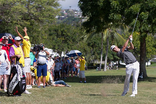 As the gallery watches, Justin Thomas hits off the rough on the third hole Sunday during the final round of the Sony Open in Honolulu.