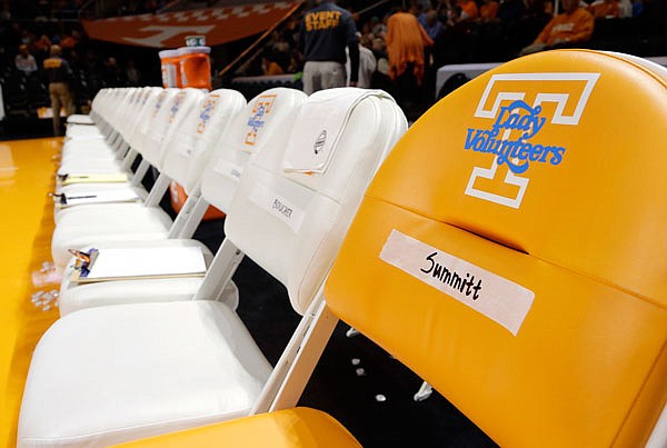 In this Dec. 4, 2016, file photo, an orange chair labeled for Pat Summitt sits at the end of the Tennessee women's bench before a game between Tennessee and Baylor in Knoxville, Tenn. In addition to the chair, Tennessee players are wearing commemorative patches on their uniforms to honor Summitt, who died June 28. Other women's basketball programs without direct connections to Summitt also are finding ways to honor one of the game's greatest ambassadors in the season after her death.