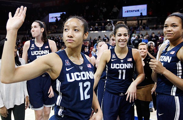 Connecticut guard Saniya Chong (12) and her teammates wave to fans after Saturday's game against SMU in Dallas. Connecticut won 88-48, its 91st straight win.