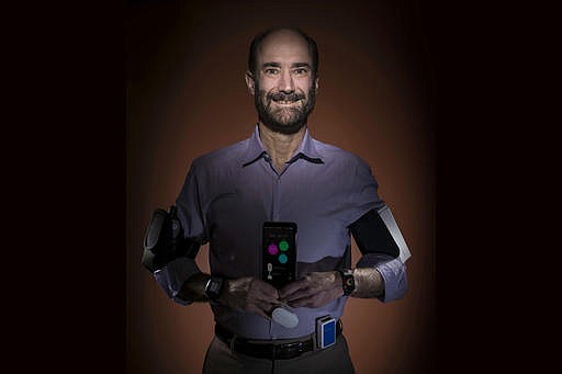 In this photo provided by Steve Fisch, Michael Snyder, professor and chair of genetics at the Stanford University School of Medicine sports wearable gadgets. Wearable gadgets gave a Snyder an early warning that he was getting sick before he ever felt any symptoms of Lyme disease. (Steve Fisch via AP)