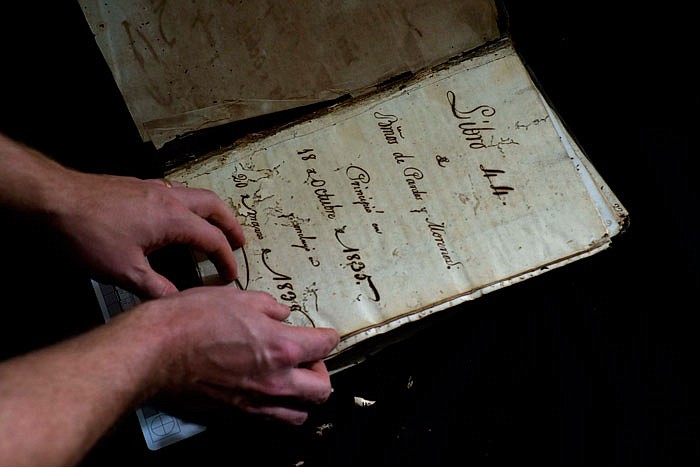 U.S. history professor David Lafevor handles a colonial-era black registry at the Espiritu Santo Church in Old Havana, Cuba. 