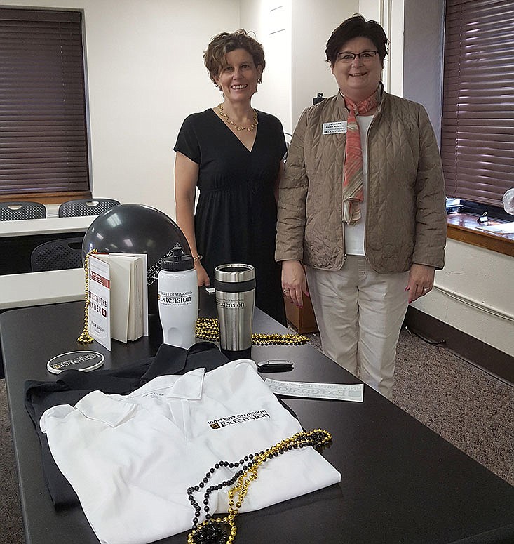 Rebecca Mott (left), research assistant community development Extension, and Johanna Reed Adams, Ph.D., state community leadership development Extension specialist showcase some of the giveaways for last summer's Leadership Online for Today launch party. 