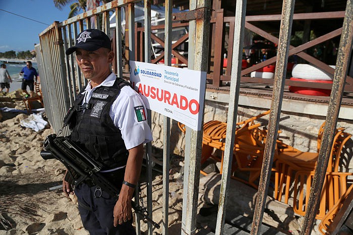 Police guard the exit of the Blue Parrot nightclub in Playa del Carmen, Mexico, Monday.