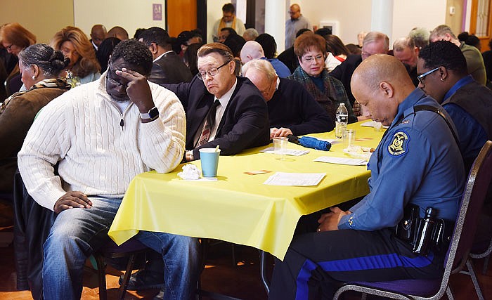Breakfast guests bow their heads in prayer during Monday's Martin Luther King Jr. Prayer Breakfast at Quinn Chapel AME.