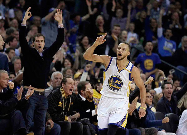 Stephen Curry of the Warriors celebrates a score against the Cavaliers during the first half of Monday's game in Oakland, Calif.