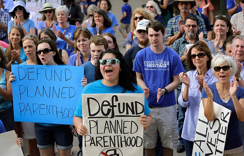 In this July 28, 2015 file photo, Erica Canaut, center, cheers as she and other anti-abortion activists rally on the steps of the Texas Capitol in Austin, Texas, to condemn the use in medical research of tissue samples obtained from aborted fetuses. Texas is moving forward with booting Planned Parenthood from Medicaid despite federal judges stopping other Republican-controlled states from doing the same. But a string of recent victories for the nation's largest abortion provider will be tested in 2017 under a new president.