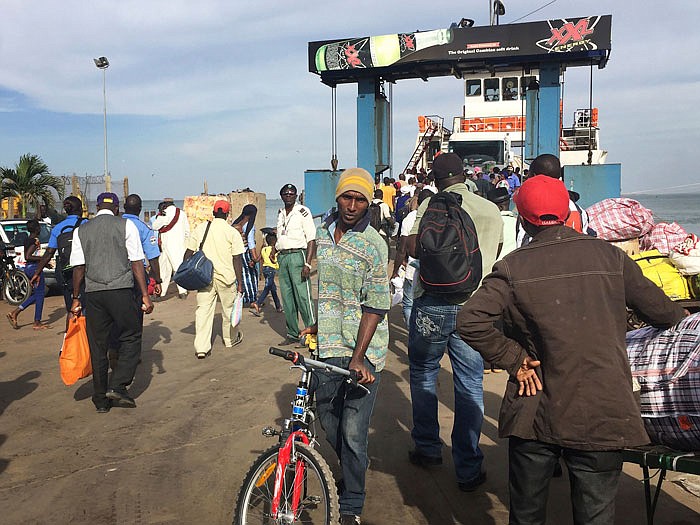 People board the ferry leaving Banjul, Gambia, Wednesday. Special flights were being organized Wednesday to evacuate British and other tourists from Gambia, where the threat of a regional military intervention loomed as President Yahya Jammeh's mandate expires on Thursday after he lost elections in December. 