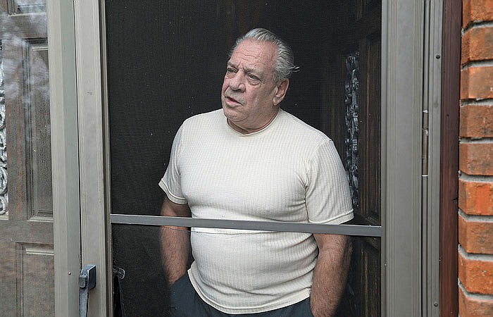 Russell Yates, whose wife Elaine and two daughters went missing in 1985, speaks in the doorway of his home Tuesday in Warwick, Rhode Island. Elaine Yates, living under the name Leina Waldberg in Houston, was arrested Monday, charged with taking the children.