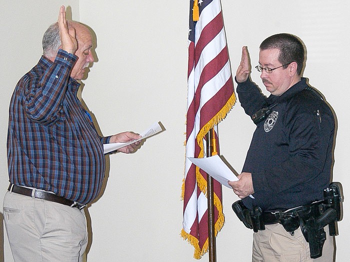 California Police Officer Daniel Hurt, right, is sworn in Jan. 9, 2017, by City Clerk Brian Scrivner in the California City Hall public meeting room.