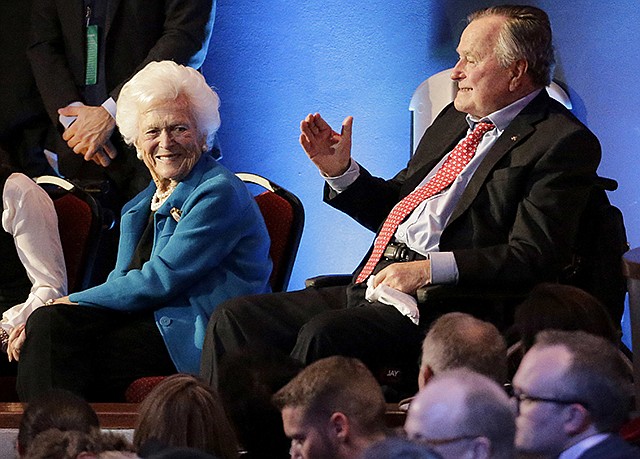 Former President George H. W. Bush, right, and his wife, Barbara, are greeted in February 2016 before a Republican presidential primary debate at The University of Houston in Houston. On Wednesday, the former president was admitted to an intensive care unit, and Barbara was hospitalized as a precaution, according to his spokesman.