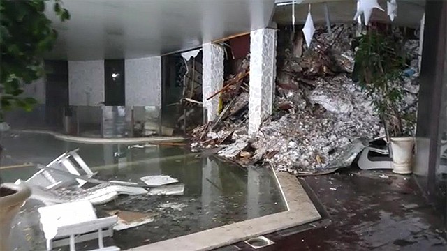 This photo taken from a video shows piles of snow and rubble Thursday cascading down the stairway into the foyer of the Hotel Rigopiano in Farindola, Italy. Italian media say the avalanche covered the three-story hotel in the central region of Abruzzo on Wednesday evening.