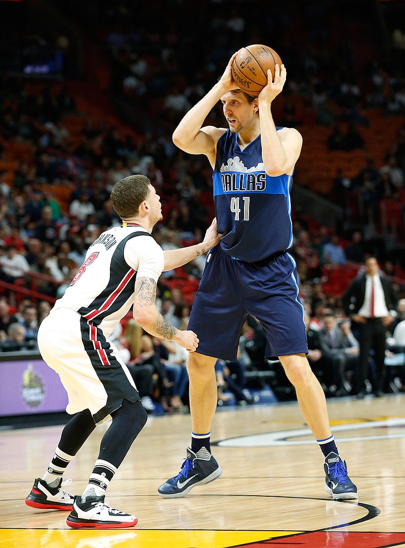 Dallas Mavericks forward Dirk Nowitzki, right, of Germany, looks for an open teammate past Miami Heat guard Tyler Johnson (8) during the first half of an NBA basketball game, Thursday, Jan. 19, 2017, in Miami. 