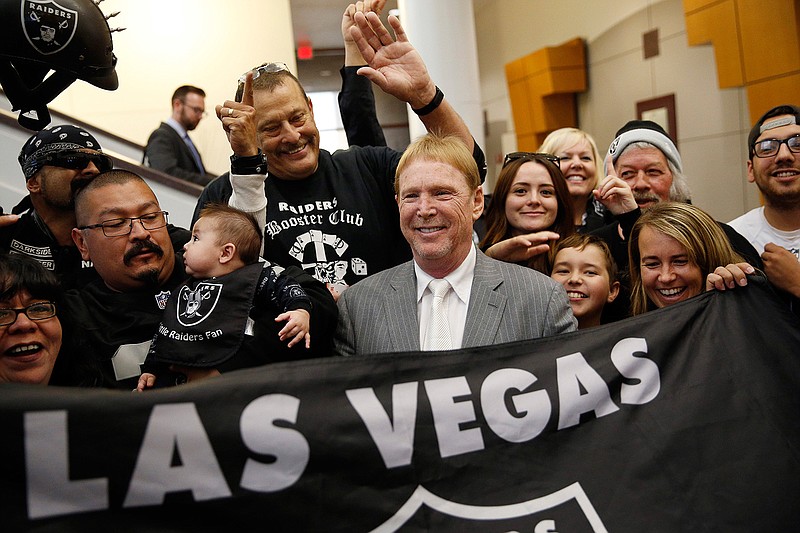 In this April 28, 2016, file photo, Oakland Raiders owner Mark Davis, center, meets with Raiders fans after speaking at a meeting of the Southern Nevada Tourism Infrastructure Committee in Las Vegas. The Raiders have filed paperwork to move to Las Vegas. Clark County Commission Chairman Steve Sisolak told The Associated Press on Thursday, Jan. 19, 2017,  that he spoke with the Raiders.